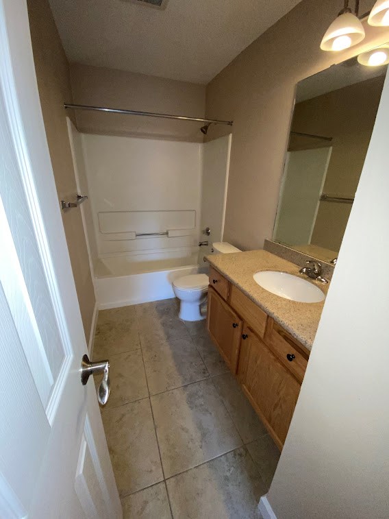 A bathroom with a toilet, sink, and mirror.