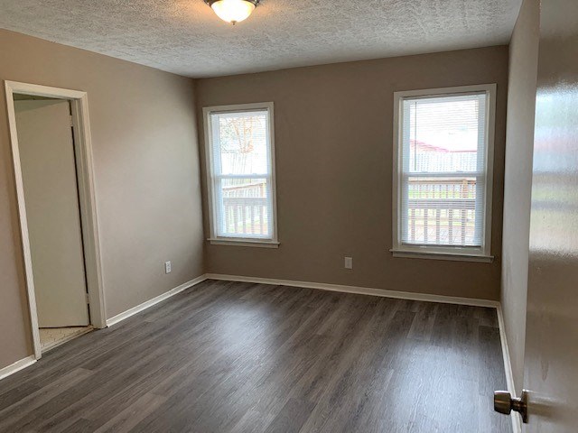an empty living room with wood floors and a door