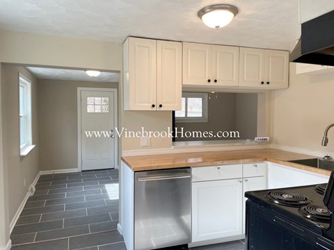 A kitchen with a stove top oven and a dishwasher.