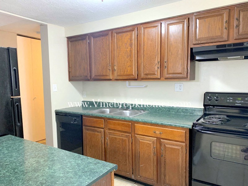 a kitchen with black appliances and green counter tops