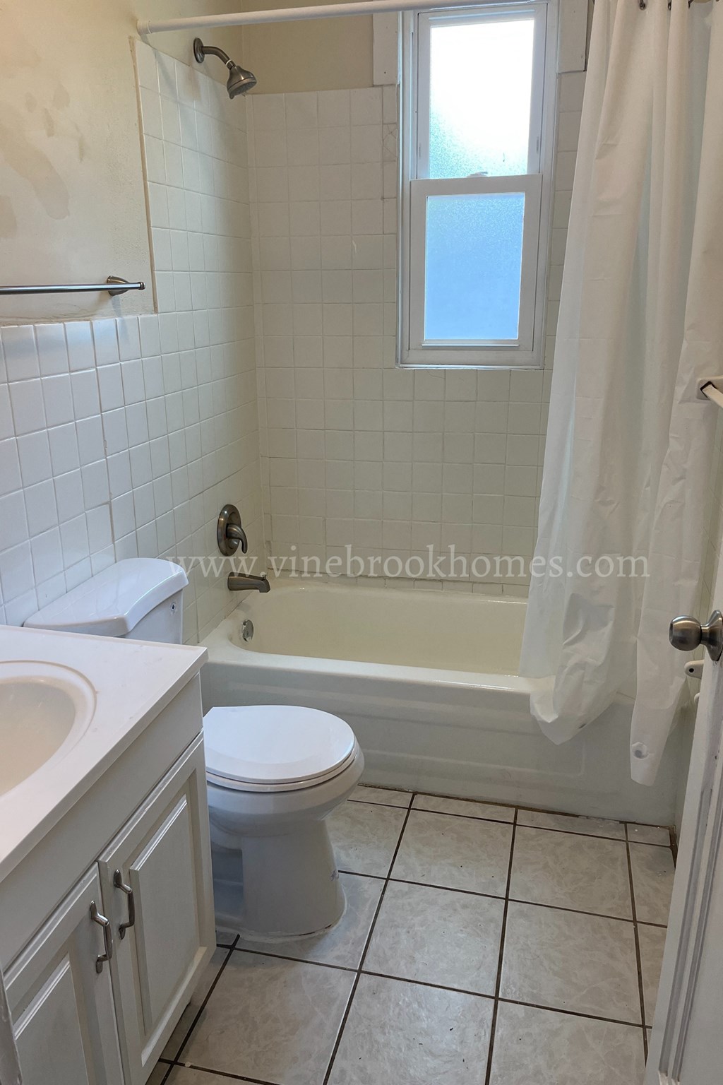 a white bathroom with a toilet and a tub and a sink