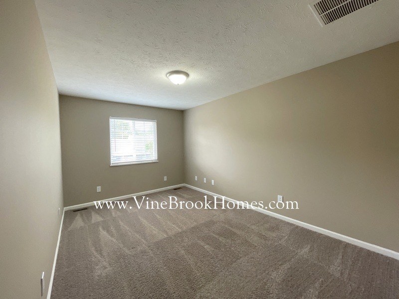 a bedroom with a carpeted floor and a window