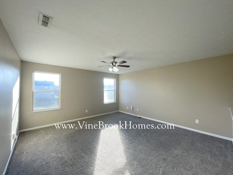 a living room with carpet and a ceiling fan