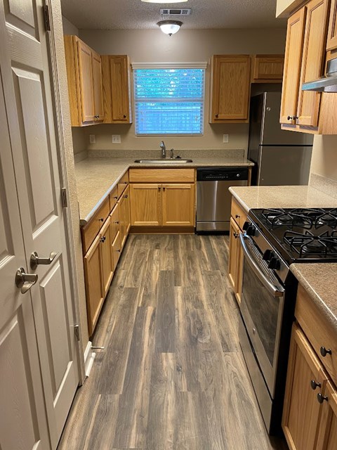 A kitchen with wooden cabinets and a black stove top.