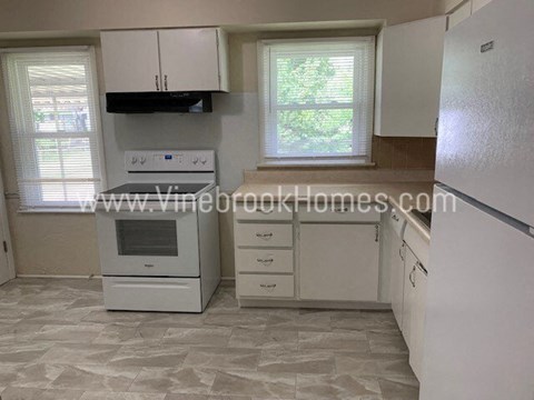 a kitchen with white appliances and white cabinets