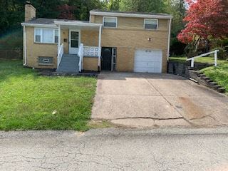 a house with a cracked driveway in front of it