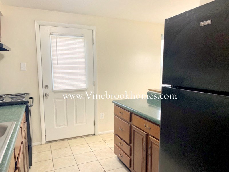 a kitchen with a refrigerator and a sink and a door