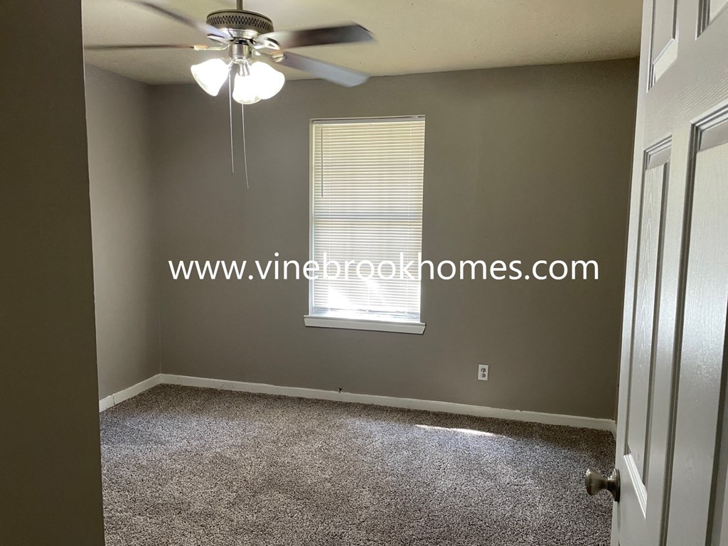 a small bedroom with a ceiling fan and a window