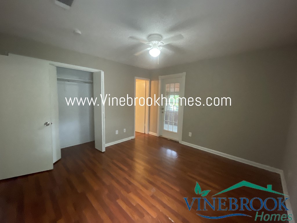 a small living room with a hard wood floor and a ceiling fan