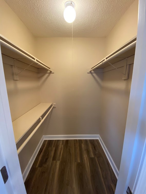 A hallway with a light on and wood floors.