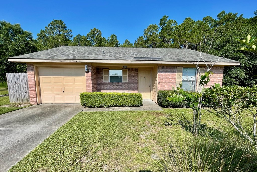 a brick house with a driveway and a garage door