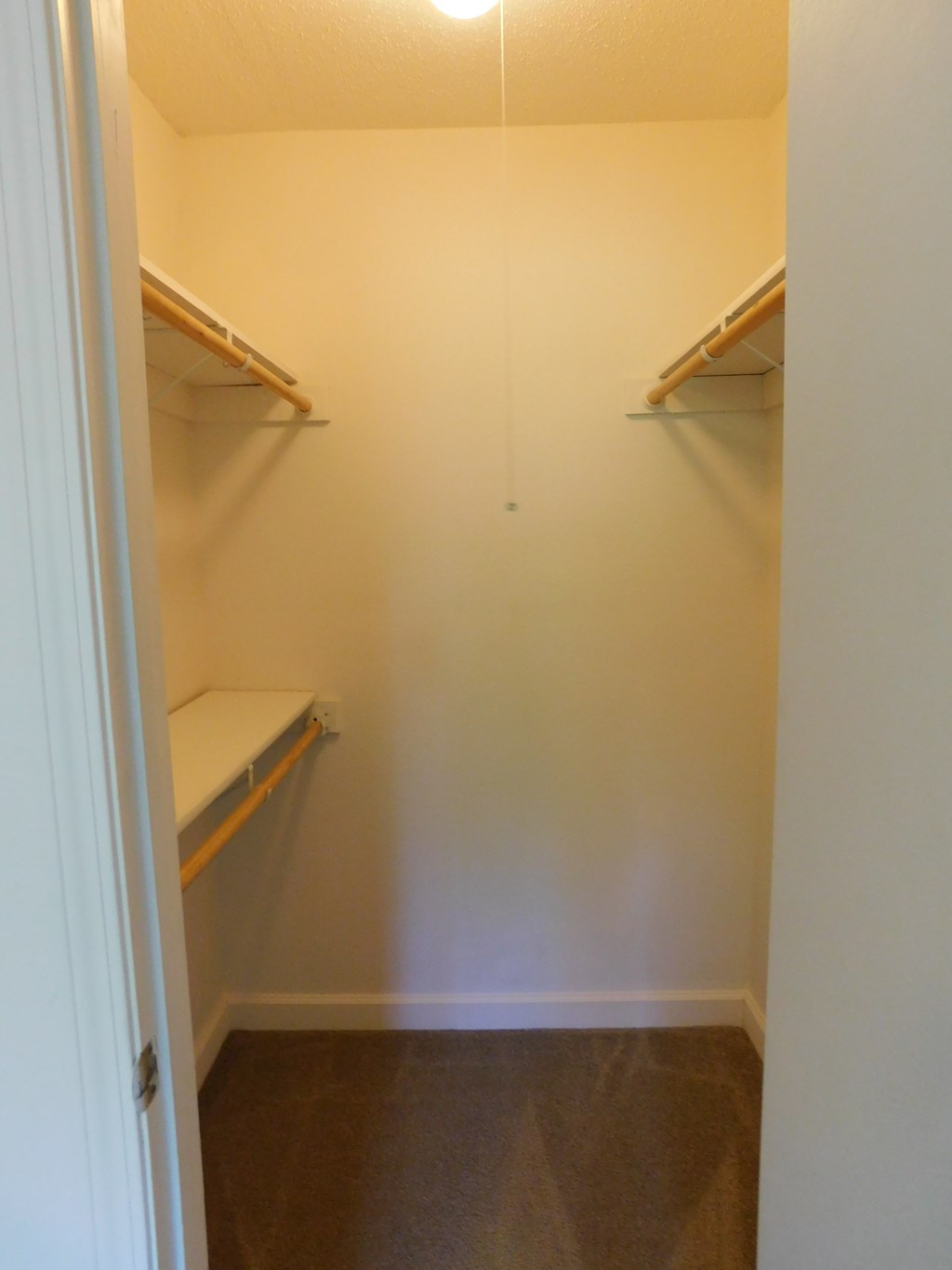 A white door opens to a small pantry with two shelves.