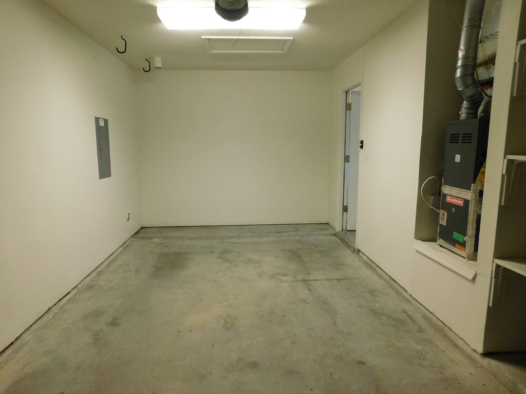 A room with a white door and a white wall with a vent on the right side.