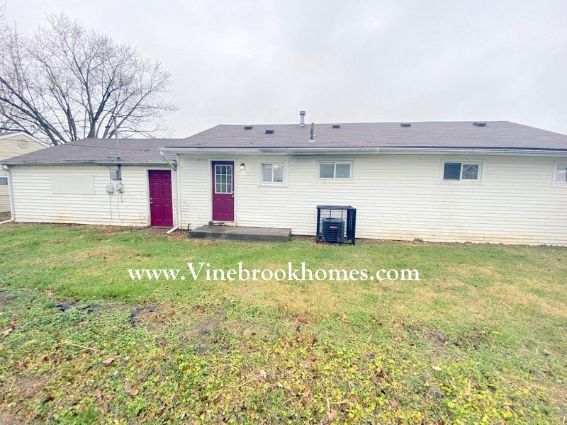 a white house with red doors and a yard