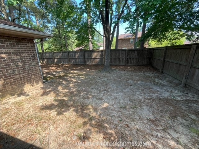 the backyard of a house with a fence and trees