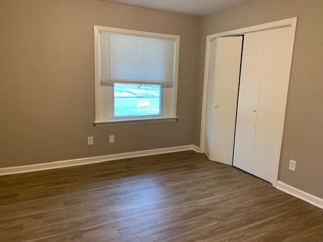 an empty room with wooden floors and a window