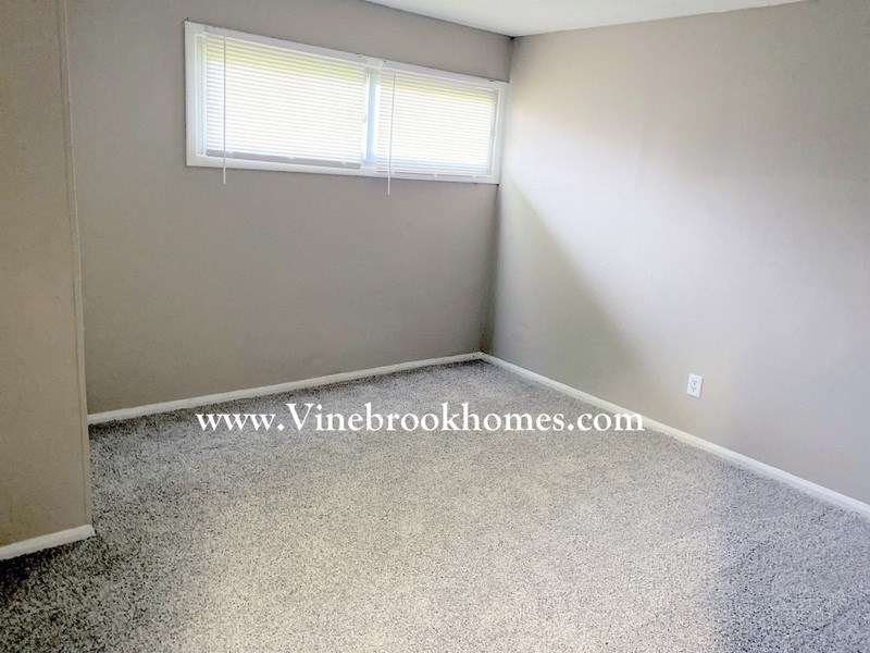 a small room with carpet and a window