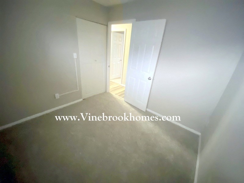 a bedroom with a closet and a door open to a hallway