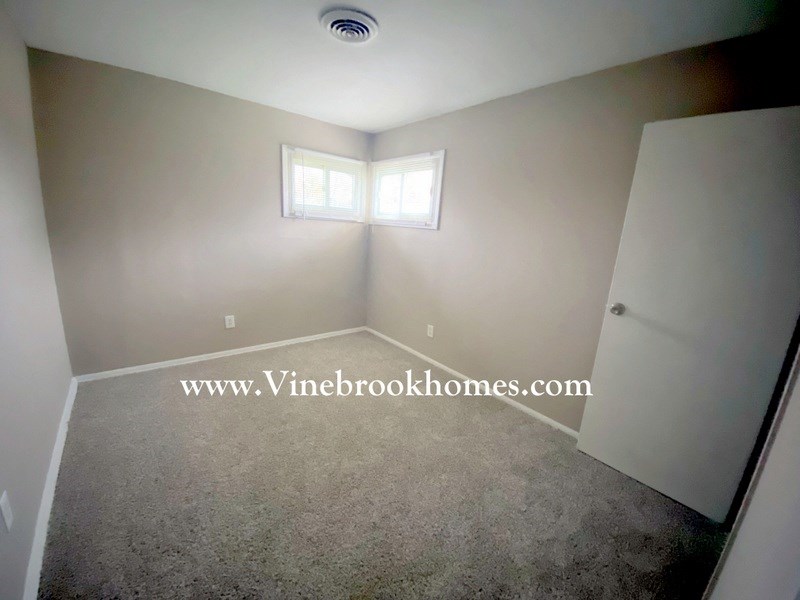 a small white room with a closet and a window