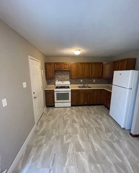 an empty kitchen with a refrigerator and a stove and