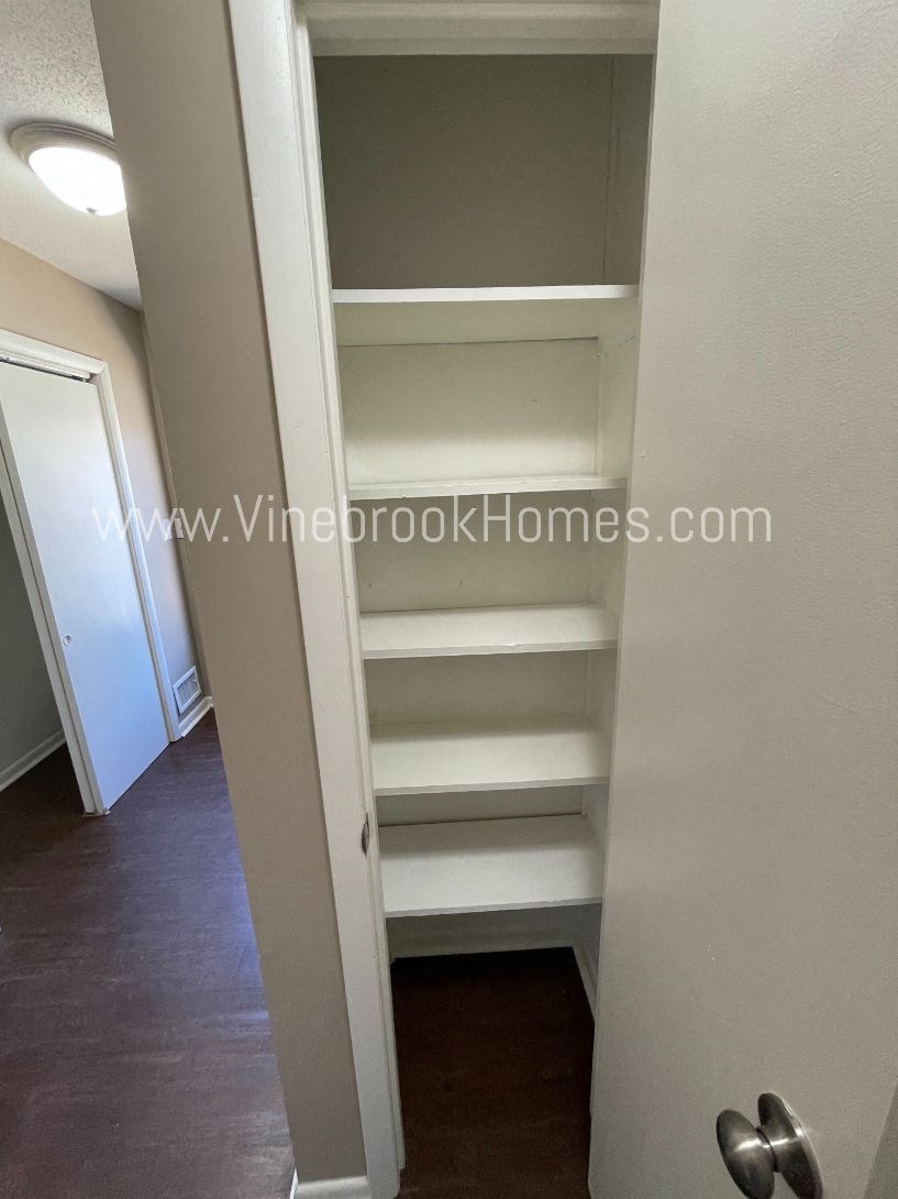 a walk in closet with empty shelves in a closet