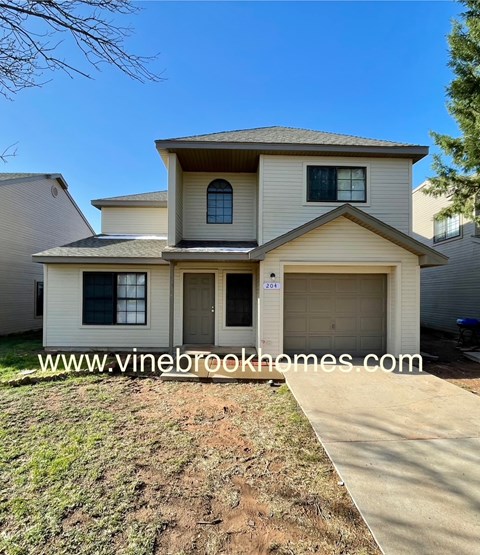 A two-story house with a garage is for sale.