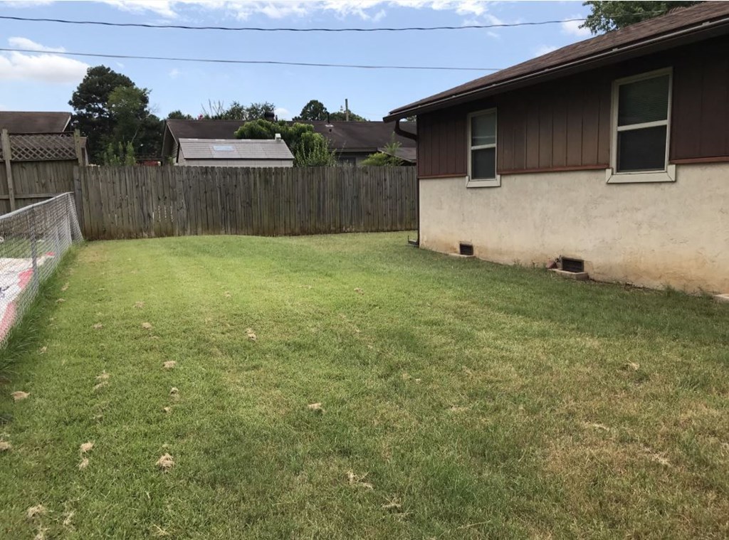 the backyard of a house with a yard and a fence