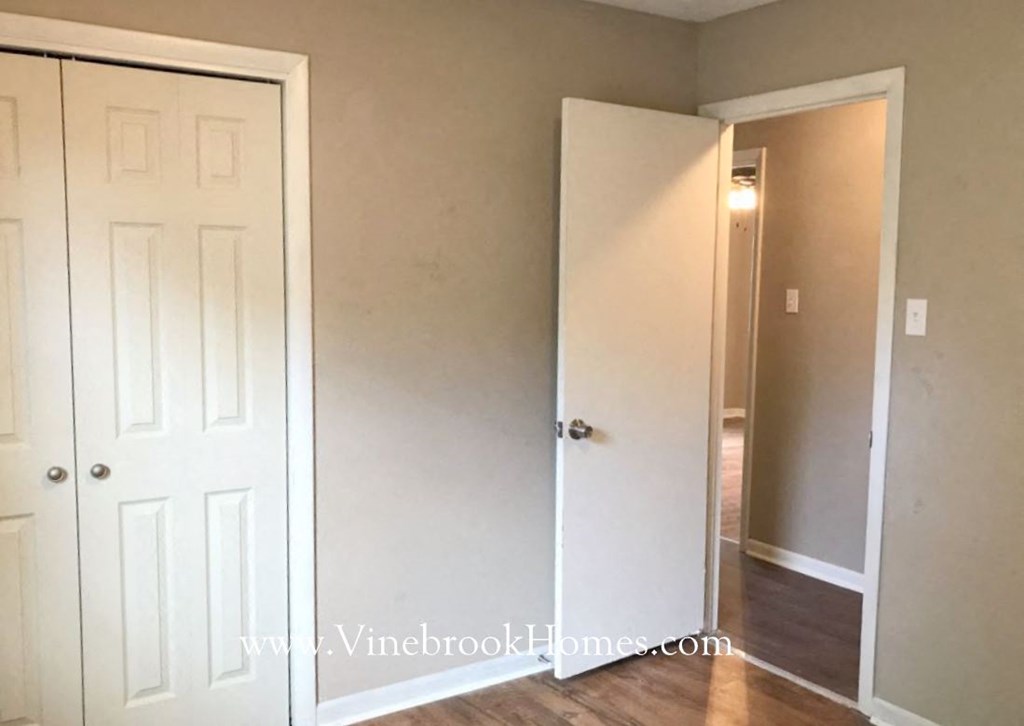 an empty room with a closet and a white door