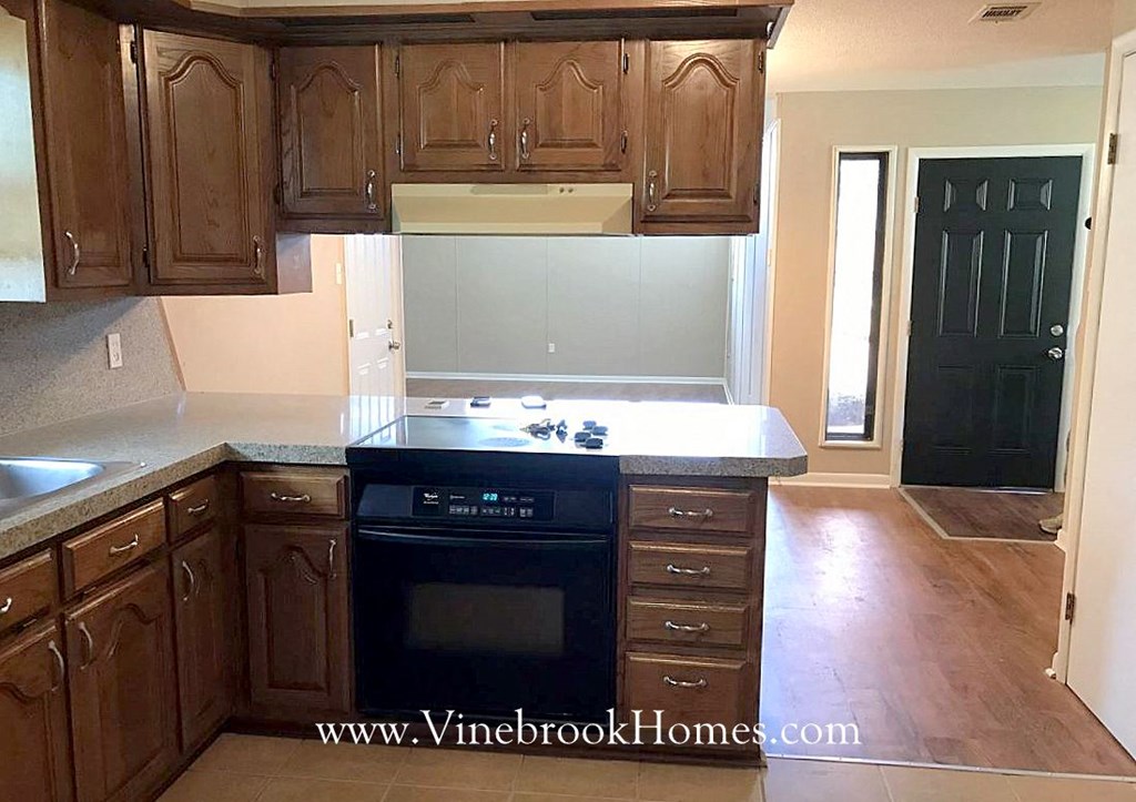 a kitchen with wooden cabinets and a black stove