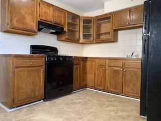 A kitchen with wooden cabinets and black appliances.