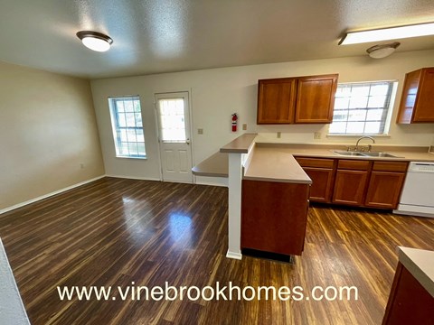a view of a kitchen and a living room with wood flooring and