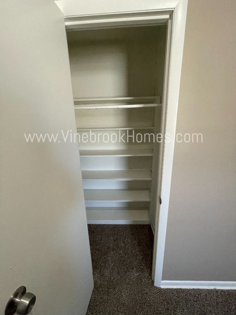 a closet with empty shelves in a small closet