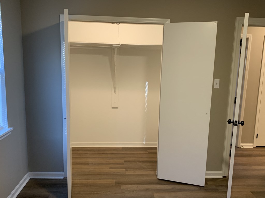 a room with a closet and a hard wood floor