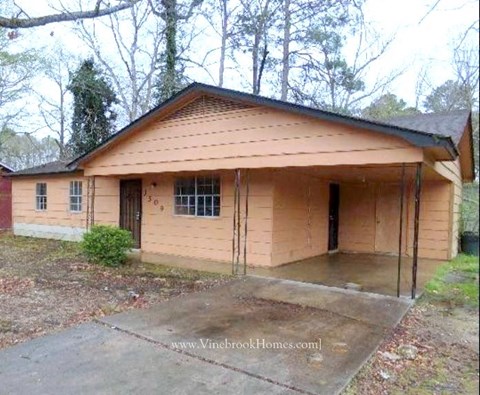 a small house with a porch and a garage