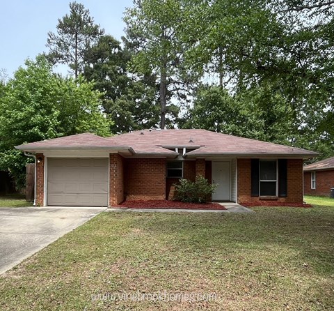 A brick house with a garage door and a driveway.