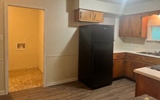 a kitchen with a black refrigerator and a sink