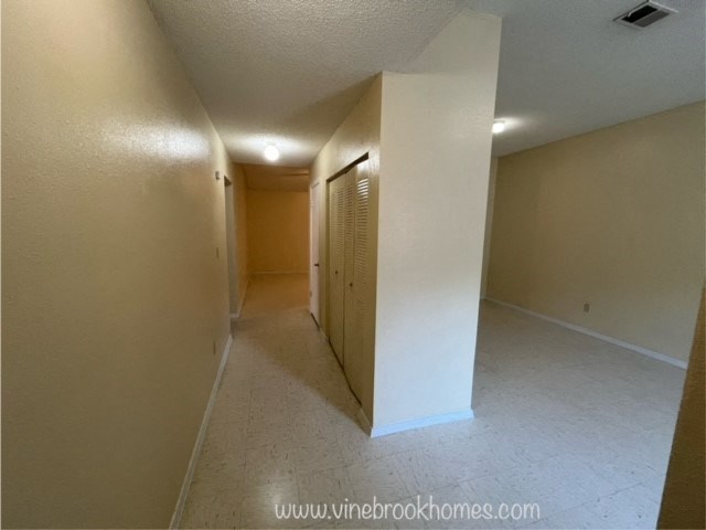 the living room and hallway of an empty apartment