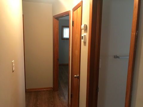 a bedroom with a door open to a hallway and a closet