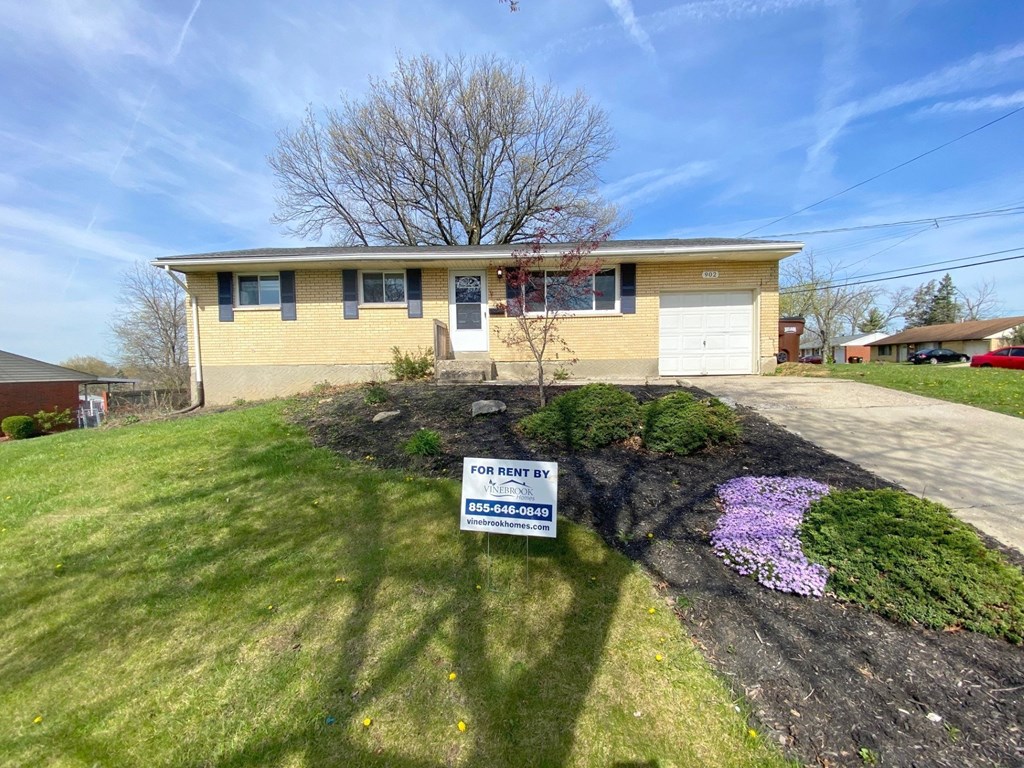 a yellow house with a sign in front of it