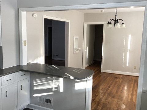A kitchen with white cabinets and a black countertop.