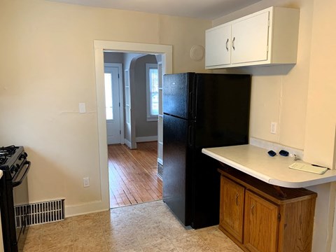 A black refrigerator in a kitchen with a white counter.