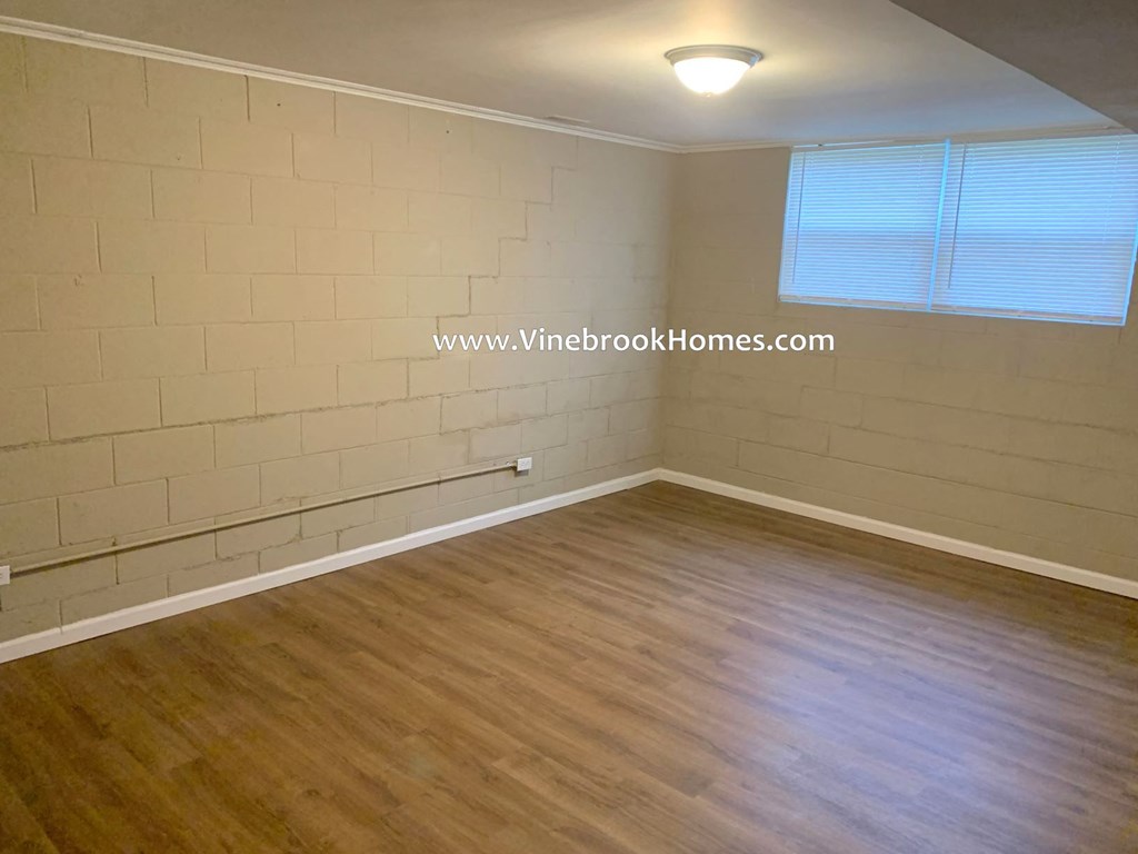 a small room with a wood floor and a brick wall