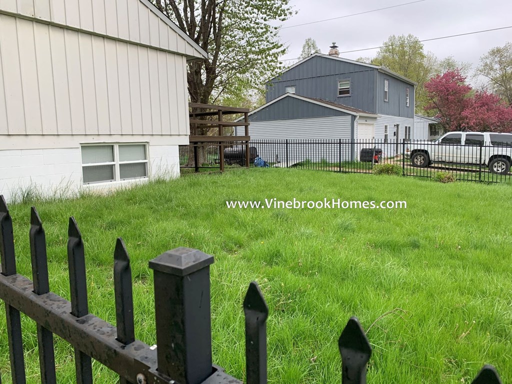 a fence in a yard in front of a house