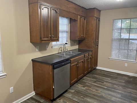 a kitchen with wooden cabinets and a sink and a window