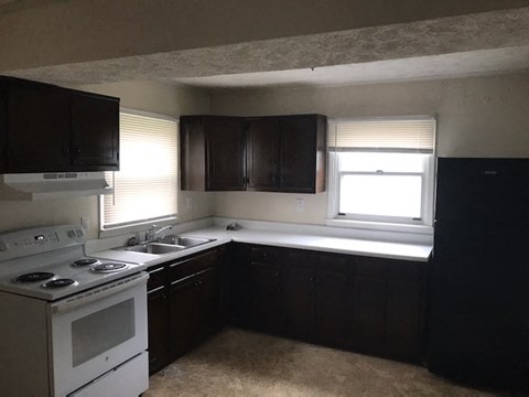 a kitchen with a stove and a sink and a window
