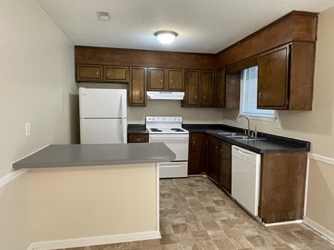 A kitchen with a white refrigerator and a black countertop.