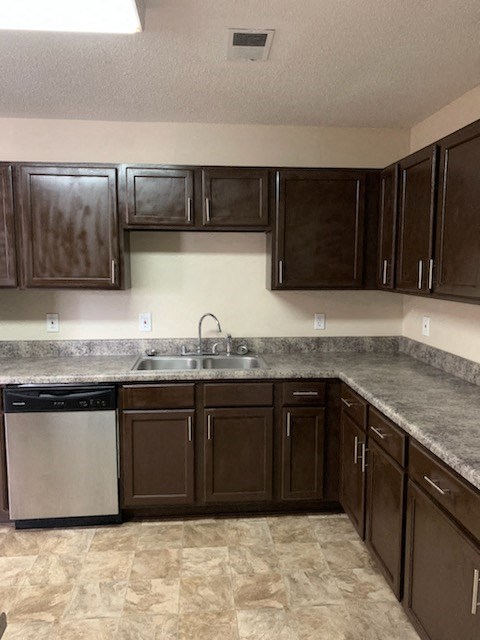 A kitchen with brown cabinets and a granite countertop.