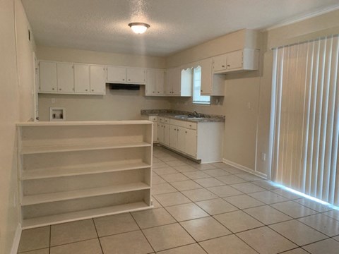 A kitchen with white cabinets and appliances.