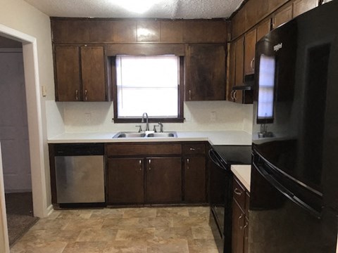 a kitchen with a sink and a refrigerator and a window