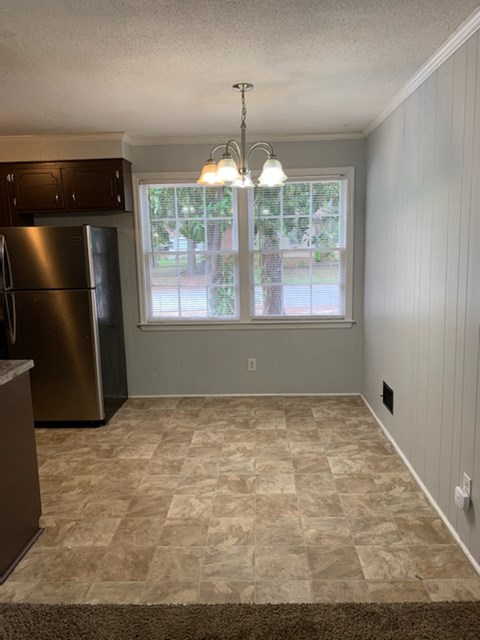 A kitchen with a refrigerator and a window.